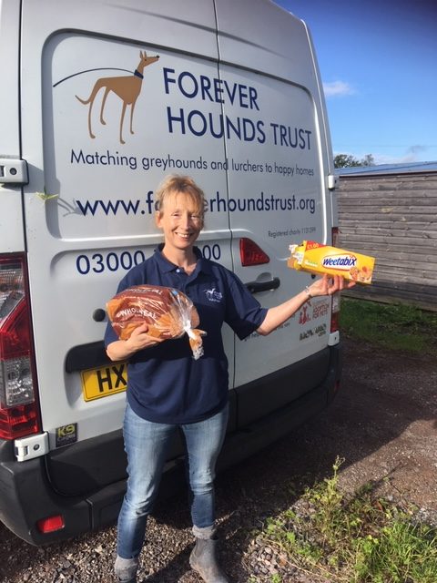 Forever Hounds Trust volunteer in front of the Forever Hounds Trust van with a box of Weetabix and a loaf of bread
