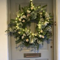 Handmade festive Christmas wreath with greenery and decorations for a charity Christmas wreath making workshop