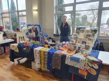 lady stood behind stall of Christmas items